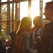 Delegates networking at an event drinks reception, group of business people talking at networking event sharing.