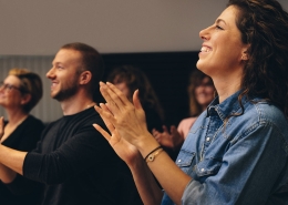 Business professionals applauding at a seminar.